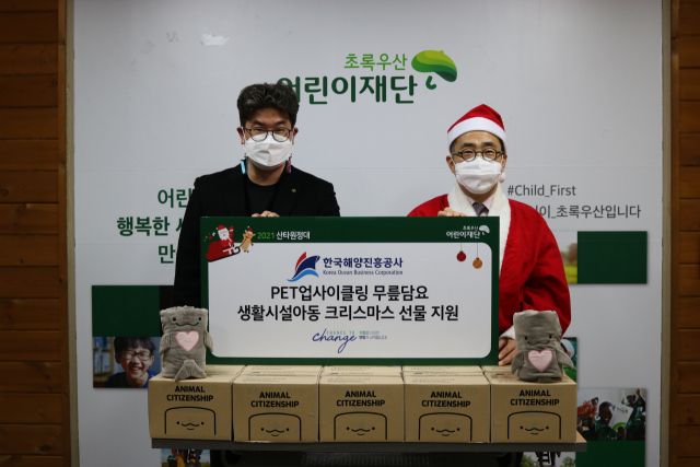 박광열 한국해양진흥공사 본부장(오른쪽)과 초록어린이재단 노희헌 부산지역본부장이 지난 8일 초록어린이재단 부산지역본부에서 PET업사이클링 무릎담요를 생활시설아동에게 전달하는 행사를 실시하고 기념촬영을 하고 있다. 해양진흥공사 제공