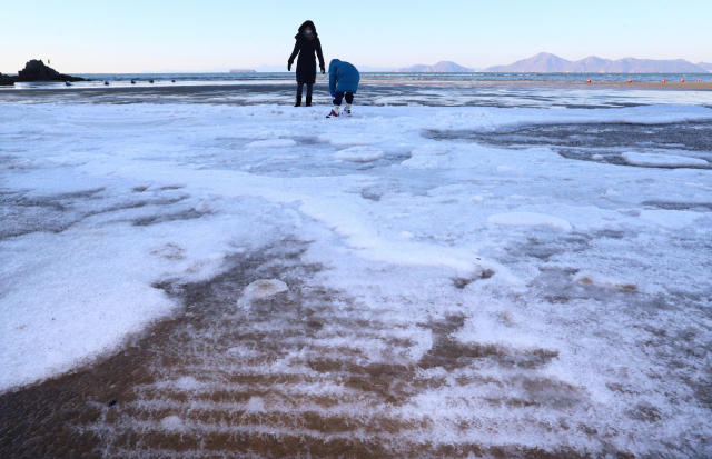 매서운 강추위가 이틀 연속 이어진 27일 오전 부산 다대포해수욕장 백사장에 밀려온 파도가 얼어붙어 하얀 설원을 연상케 하고 있다. 이날 부산의 아침 최저기온은 영하 6.9도로 차가운 날씨를 보였지만 오후부터 차가운 대륙고기압 세력이 약해져 예년 기온을 되찾을 전망이다. 정종회 기자 jjh@