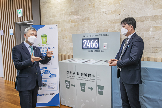 28일 한국남동발전 진주 본사에서 김회천 사장(왼쪽)이 다회용컵 공유시스템 도입에 대한 설명을 듣고 있다. 남동발전 제공