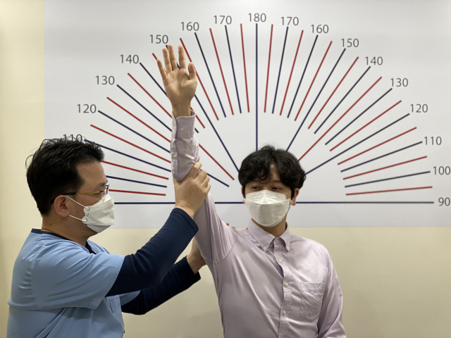 좋은삼선병원 조형래 어깨관절 스포츠의학센터장이 환자의 팔을 들어올리면서 어깨질환 여부를 진단하고 있다. 좋은삼선병원 제공