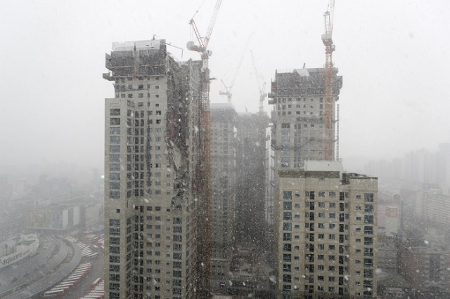 외벽 붕괴사고가 발생한 광주 서구 화정아이파크 주상복합아파트 현장. 13일 오후 실종자 수색이 이어지는 현장에 눈이 쏟아지고 있다. 연합뉴스