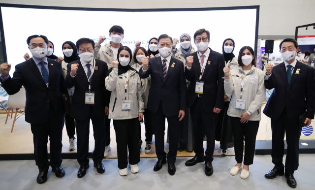 문재인 대통령이 지난 17일(현지시간) 아랍에미리트(UAE) 두바이 엑스포 전시센터의 2030 부산엑스포 홍보부스에서 현지 서포터즈들과 기념촬영을 하고 있다. 문 대통령은 이 자리에서 