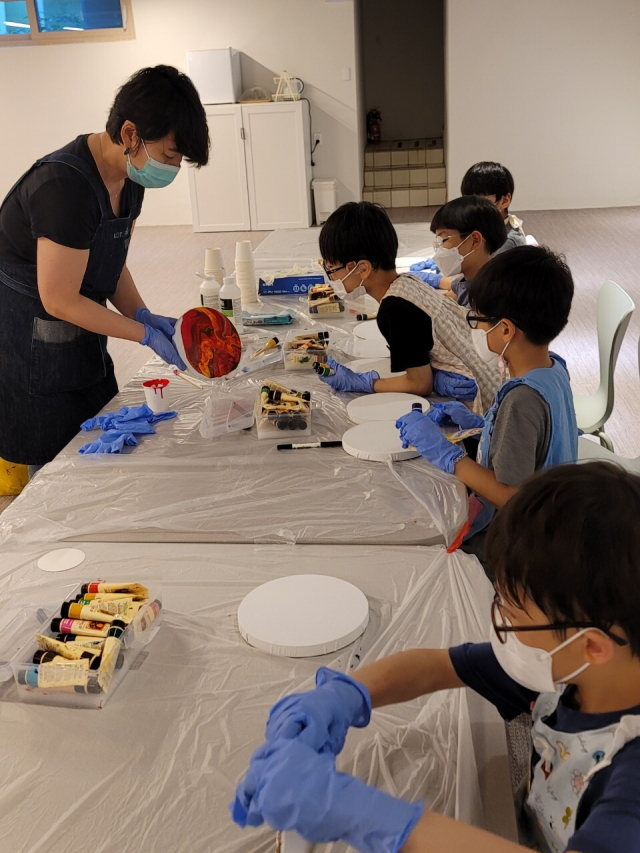 이정윤 작가는 희락원 아이들을 대상으로 ‘희희락락 아트 트렁크’ 프로젝트를 진행했다. 사진은 자신만의 추상화 ‘열다섯 우주’를 제작하는 장면. 희락원 제공