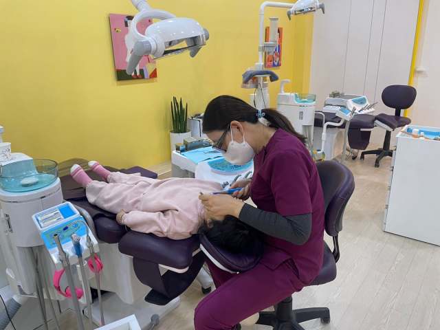 영유아의 첫 치과 방문은 돌 즈음이 좋다. 센텀어린이치과의원 이민정 원장이 구강 검진을 하면서 충치가 있는지를 확인하고 있다. 센텀어린이치과의원 제공