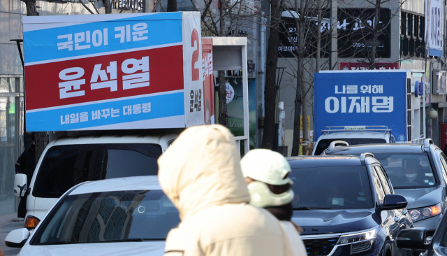 국민의당 안철수 대선후보의 유세차 '사망 사고'로 여야 후보들이 유세차 스피커를 끄고 '차분한' 선거운동을 하기로 한 16일 서울 시내에 국민의힘 윤석열 후보와 민주당 이재명 후보의 유세차량이 세워져 있다. 연합뉴스