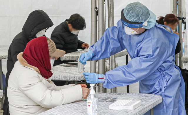 전국 코로나19 신규확진자가 17만 1천452명을 기록한 23일 오전 부산 연제구 시청 등대광장 임시선별검사소에서 시민들이 의료진의 안내에 따라 신속항원검사를 하고 있다. 김종진 기자 kjj1761@