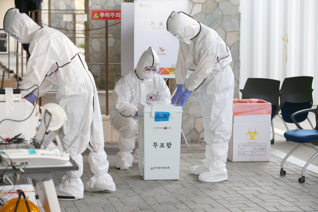 다음 달 9일 제20대 대통령 선거일이 다가오면서 투표 당일 100만 명에 달할 것으로 예상되는 코로나 재택치료자의 투표권 행사에 관심이 쏠린다. 2020년 21대 총선 때 사전투표일을 앞두고 선거관리 요원들이 방호복을 입고 코로나 환자의 투표를 준비하고 있다. 연합뉴스
