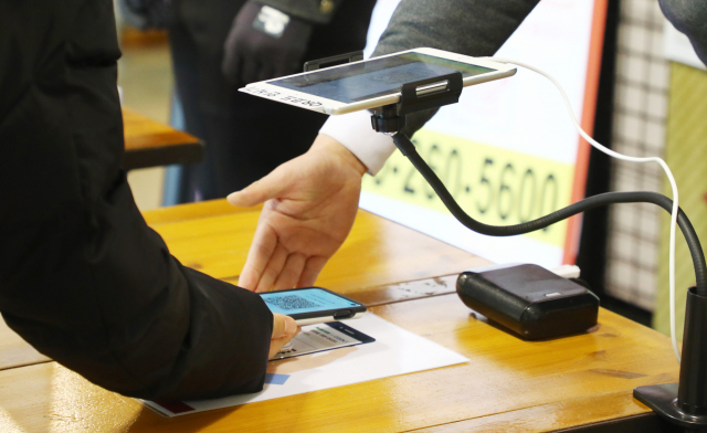 정부가 1일부터 식당과 카페 등 다중이용시설 11종에 적용해 오던 방역패스를 전면 중단하기로 했다. 부산 수영구의 한 대형마트에서 시민들이 코로나19 백신 접종 완료 여부를 확인하고 있다. 부산일보db