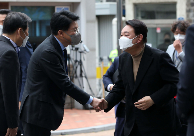 윤석열 대통령 당선인이 14일 오전 서울 종로구 통의동 금융감독원 연수원에 마련된 당선인 집무실로 출근하며 장제원 비서실장과 악수하고 있다. 연합뉴스