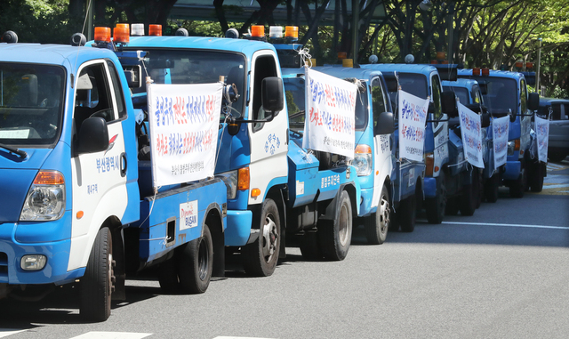 항의 민원과 코로나19 상황이 겹쳐 지자체의 불법 주정차 단속과 함께 견인 건수가 가파르게 감소하는 추세다. 사진은 2019년 8월 부산시 민간 견인업체 차량들이 시에 보조금 지원 등을 요구하며 시위를 벌이는 모습. 부산일보DB