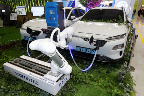 서울 강남구 코엑스에서 열린 코리아스마트그리드엑스포의 한 부스에서 전기차에 자동으로 충전 플러그를 꽂아 주는 로봇을 시연하고 있다. 연합뉴스