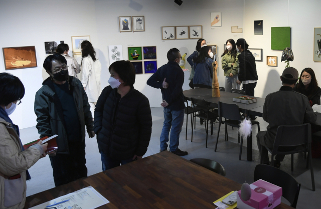 커뮤니티공간 플래그엠 기획전 '망미골목을 열다'가 개막한 15일 오후 망미골목 가게 주인들과 예술가들이 전시장에 모여 대화를 나누고 있다. 비온후 제공