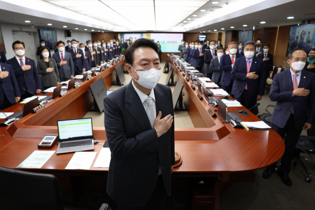 윤석열 대통령과 국무위원들이 12일 오후 서울 용산 대통령실 청사에서 열린 첫 임시 국무회의에서 국기에 경례를 하고 있다. 연합뉴스