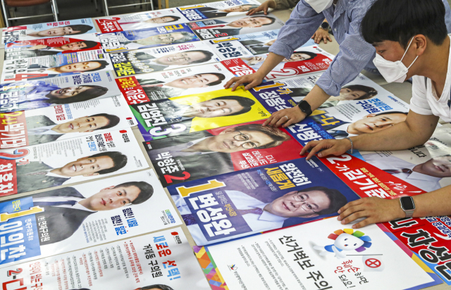 제8회 전국동시지방선거 공식 선거운동을 하루 앞둔 18일 오후 부산 연제구선거관리위원회에서 관계자들이 각 후보들이 제출한 선거벽보를 검수하고 있다. 김종진 기자 kjj1761@
