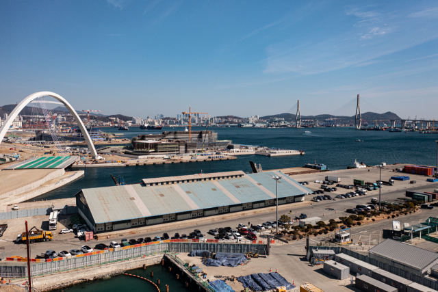 부산항 1부두 내 폐창고가 2022 부산비엔날레의 전시장으로 활용돼 일반에 처음으로 공개될 예정이다. 이후 부산시의 활용 계획에 따라 2024년까지 복합문화공간으로 조성된다. 창고 재활용은 100년 역사를 간직한 1부두의 가치와 의미, 사람들의 숨결과 삶의 애환을 담아내는 방향으로 가는 게 바람직하다. 가운데 보이는 파란색 지붕 건물이 1부두 창고다. 부산비엔날레조직위 제공