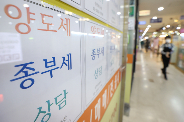 정부가 1세대 1주택 보유세 부담을 2020년 수준으로 추가 완화하는 방안을 추진하면서 1주택자의 세금 부담이 사례에 따라 절반 아래까지 떨어질 전망이다. 업계에 따르면 언제 공시가격을 적용하느냐에 따라 1세대 1주택자의 재산세·종합부동산세 등 보유세 부담은 큰 폭으로 달라진다. 사진은 23일 서울의 부동산 중개업소 안내문. 연합뉴스