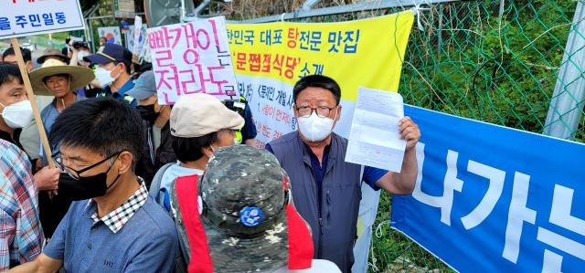 평산마을 주민들이 24일 문재인 전 대통령 사저 앞에서 1인 시위를 벌이고 있는 시위자에게 어르신들의 진단확인서를 보여주면서 집회 자제를 촉구하고 있다. 김태권 기자