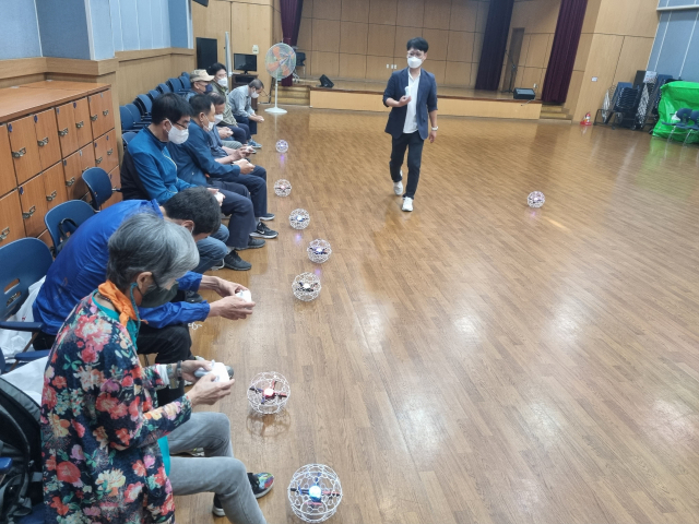 성산노인복지관의 시니어 드론 체험교실에 참가한 어르신들이 드론 비행 체험을 하고 있다. 창원시설공단 제공