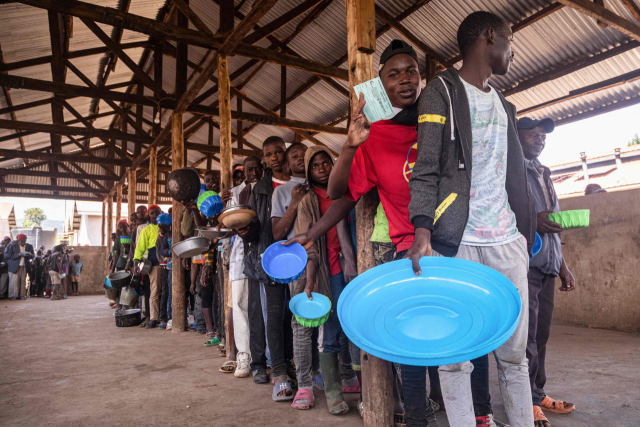 콩고민주공화국(DRC)에서 온 난민들이 지난 7일 우간다 기소로의 냐카반데 교통센터에서 점심을 받기 위해 줄을 서서 기다리고 있다. AFP연합뉴스