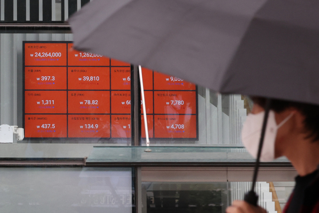 비트코인 가격이 주말 사이 1만 9000달러 선 아래로 떨어지는 등 가상화폐 가격이 급락한 19일 시세 전광판이 설치된 서울 서초구 빗썸 고객센터 앞을 한 시민이 지나가고 있다. 이날 빗썸에서 비트코인은 2400만 원 초반대까지 떨어져 거래되고 있다. 연합뉴스