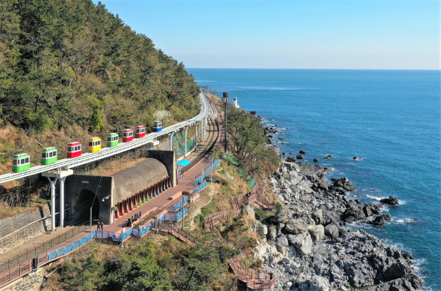 동해남부선 폐선 부지를 활용한 해운대블루라인파크가 부산 관광의 핫 플레이스로 부상하고 있다. 해운대블루라인파크의 스카이캡슐이 푸른 동해를 바라보면서 철로 위를 느긋하게 운행하고 있다. 해운대블루라인파크 제공