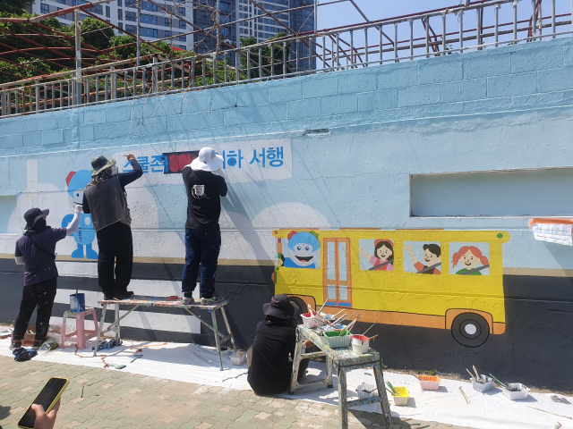 부산 남부경찰서는 지난 22일 수영구 남천동 삼익유수풀장 외벽에 ‘스쿨존 교통안전’ 메시지를 담은 벽화를 그렸다고 28일 밝혔다. 부산 남부경찰서 제공