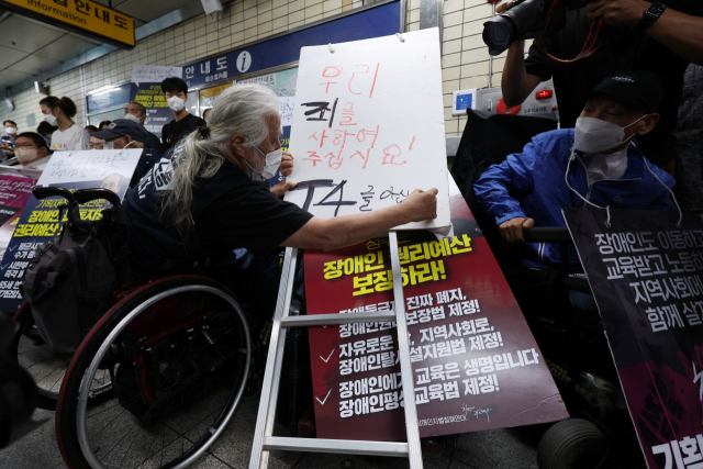 박경석 전국장애인차별철폐연대(전장연) 상임공동대표와 활동가들이 지난달 13일 오전 서울 혜화역에서 지하철 집회를 재개하며 장애인권리예산과 이동권 보장을 촉구하고 있다. 연합뉴스