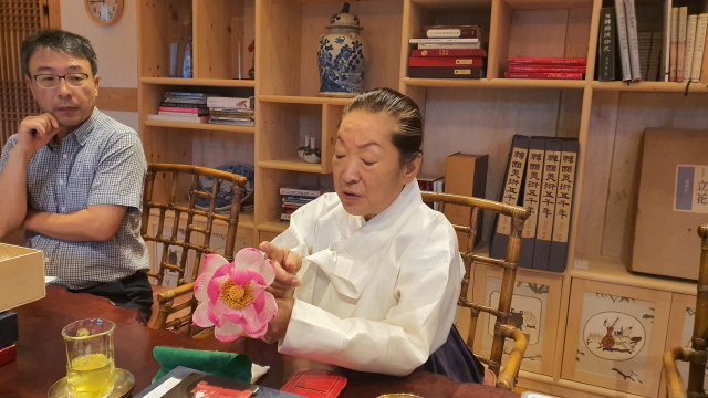 사재 150억 원 등 200억 원을 들여 궁중꽃박물관을 건립한 황수로 채화장이 비단과 종이를 이용해 만든 궁중채화를 설명하고 있다. 김태권 기자