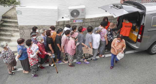 심각한 경기 침체에다 전방위로 덮친 고물가 쓰나미로 취약계층의 기초적인 생활마저 크게 위협받고 있다. 6일 부산 서구 아미동을 찾은 부산연탄은행 무료도시락 나눔 차량에서 어르신들이 줄지어 도시락을 받아 가고 있다. 김종진 기자 kjj1761@