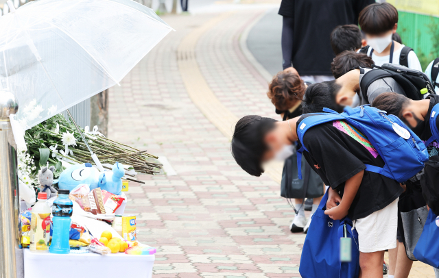 전날 신호를 무시하고 주행하던 굴착기에 초등학생이 치어 숨진 경기도 평택시의 한 초등학교 앞 횡단보도에 마련된 추모 장소에 8일 오후 학생과 학부모의 추모 발길이 이어지고 있다. 연합뉴스