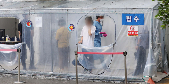 중앙방역대책본부가 10일(0시 기준) 코로나19 신규 확진자가 2만 410명으로, 이틀 연속 2만 명을 넘었다고 밝히면서 코로나 재확산 경고등이 켜졌다. 지난달 말 부산 부산진구보건소 선별진료소에서 코로나 검사를 기다리고 있는 시민들. 이재찬 기자 chan@