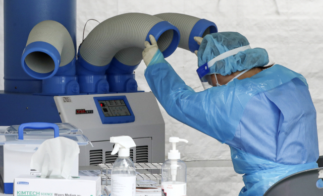 지난 6일 오후 부산 동래구보건소 선별진료소에서 의료진이 냉풍기로 무더위를 식히고 있다. 부산일보DB