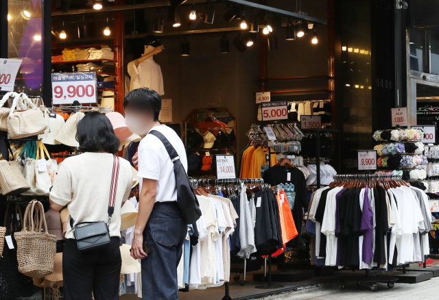 폭염이 기승을 부린 10일 오후 부산 부산진구 부전동 서면의 한 상점이 냉방기를 가동한 상태로 출입구를 열어두고 영업하고 있다. 정대현 기자 jhyun@