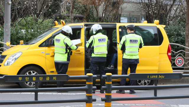 지난해 초 제주시 화북동의 학원가에서 경찰이 학원 차량의 법규 위반 사항을 점검·단속하고 있다. 기사와 직접 관련은 없음. 연합뉴스