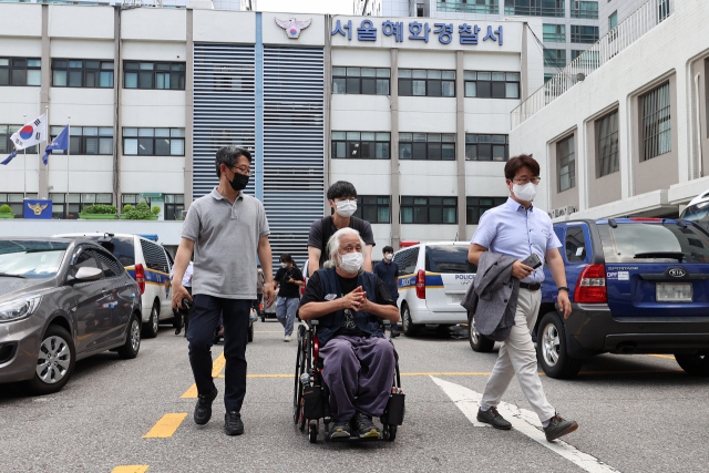 박경석 전국장애인차별철폐연대(전장연) 상임대표가 14일 오후 서울 종로구 혜화경찰서에 방문해 경찰 조사에 대한 입장문들 전달한 뒤 이동하고 있다. 박 상임대표는 이날 혜화경찰서에 엘리베이터가 설치되면 경찰 조사에 임하겠다고 밝혔다. 연합뉴스