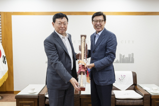 신동빈 롯데그룹 회장이 14일 부산시청을 방문해 박형준 시장에게 야구 배트를 선물하고 있다. 연합뉴스