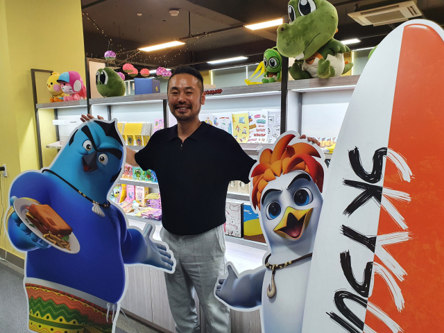 (주)빅파인애니메이션스튜디오 양창원 대표가 부산 남구 동명대 강석진스타트업빌리지 내 본사에서 ‘스카이 서퍼 인 송정’ 캐릭터와 함께 포즈를 취했다.
