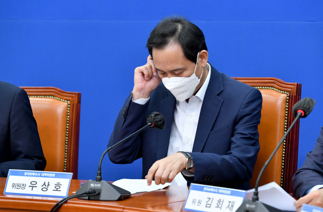 더불어민주당 우상호 비상대책위원장이 18일 서울 여의도 국회에서 열린 정치보복수사대책위원회 공개회의에서 자료를 보고 있다. 연합뉴스