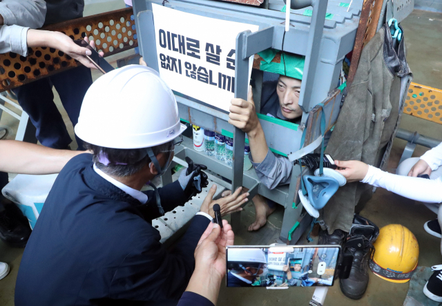 이정식 고용노동부 장관이 19일 오후 경남 거제 대우조선해양 옥포조선소 파업 현장에서 금속노조 거제통영고성조선하청지회 유최안 부지회장과 면담하고 있다. 유 부지회장은 조선소 1번 독 화물창 바닥에 만든 가로·세로·높이 1ｍ 철 구조물 안에서 농성 중이다. 연합뉴스