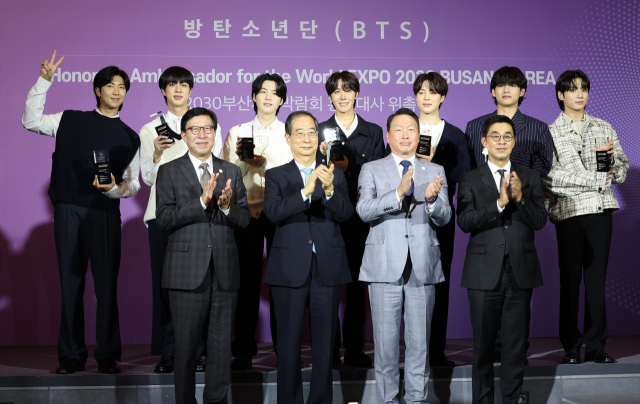 그룹 방탄소년단(BTS)이 19일 오후 서울 용산구 하이브 사옥에서 열린 ‘2030부산엑스포 홍보대사 위촉식’에서 홍보대사로 위촉된 후 참석자들과 기념촬영을 하고 있다. 연합뉴스