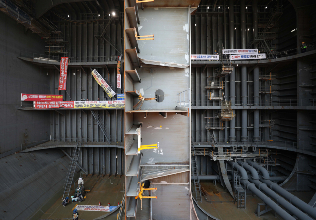 대우조선해양 하청업체 노동조합 파업이 49일째를 맞은 20일 경남 거제시 아주동 대우조선해양 옥포조선소 독에서 파업 중인 하청지회(왼쪽)와 파업 철회를 촉구하는 대우조선해양 직원이 벽 하나를 사이에 두고 농성하고 있다. 연합뉴스