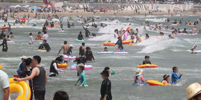 부산 해운대해수욕장을 찾은 시민과 관광객들이 물놀이를 즐기며 더위를 식히고 있다. 부산일보DB