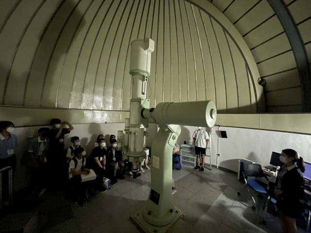 지난 18일 부산일과학고에서 열린 천문교실에서 참가자들이 천문대 돔 내부의 망원경을 살펴보고 있다.