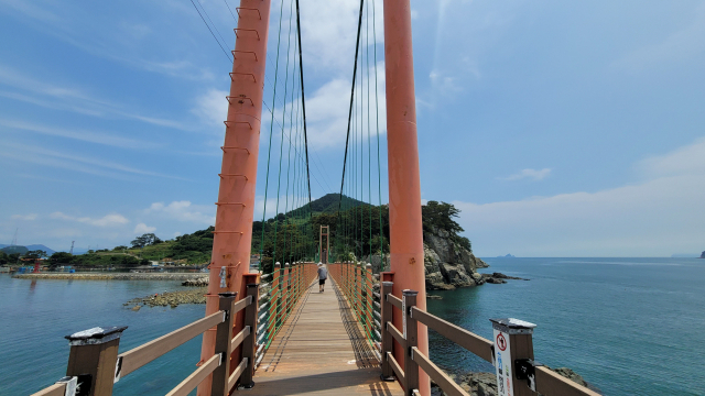 경남 통영시 산양읍의 두 섬 만지도와 연대도는 출렁다리로 이어져 있다. 만지도에서 연대도로 가는 길, 푸른 섬을 바라보며 쪽빛 바다 위를 걷는 기분이 짜릿하다.