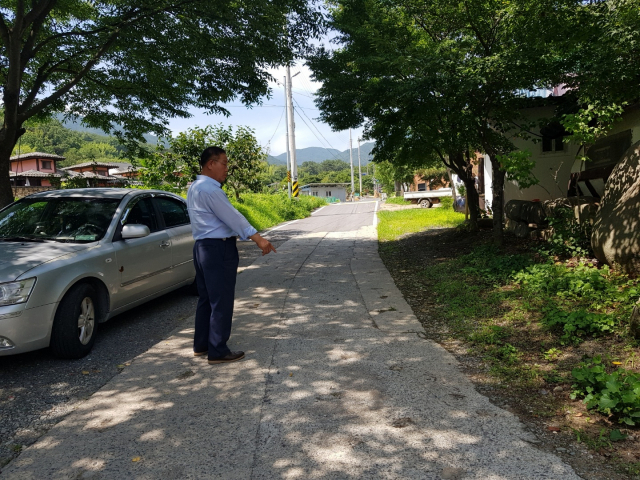 창녕군이 마을도로를 확·포장하면서 편입된 땅 지주로부터 동의나 보상 없이 구멍뚫기 작업을 시행하다가 반대에 부닥치자 반쪽만 마무리해 놓은 현장. 백남경 기자