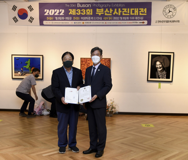 제종모(왼쪽) 부산시새마을회장은 지난달 26일 부산시청 전시실에서 제33회 부산사진대전 대상을 수상했다.