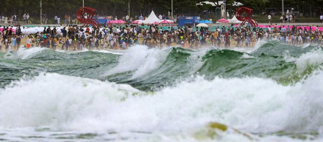 여름 피서 절정기에도 불구하고 제5호 태풍 '송다'의 간접 영향으로 흐린 날씨를 보인 31일 오후 부산 해운대해수욕장에 높은 너울성 파도와 이안류 발생 위험 등으로 입수가 금지돼 피서객들이 백사장에서 대기하고 있다. 김종진 기자 kjj1761@