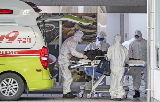코로나19 재유행의 확산세는 둔화하고 있지만 위중증 환자는 증가하고 있다. 부산의료원에서 의료진들이 코로나19 환자를 병실로 옮기는 모습. 부산일보DB
