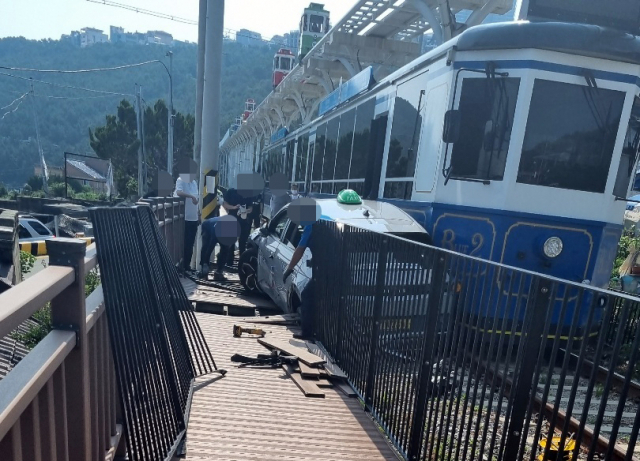 6일 오후 부산 해운대구 중동 해변열차 청사포 정거장 앞 사거리 건널목을 지나던 해변열차와 택시가 충돌해 멈춰있다. 사고 충격으로 택시 승객 1명이 두통 등을 호소해 병원으로 이송됐고, 택시와 해변열차 시설물 등이 파손됐다. 연합뉴스