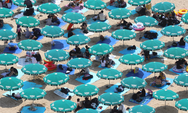 7일 오후 부산 해운대해수욕장에서 피서객들이 비치 파라솔 아래서 햇볕을 피하고 있다. 정종회 기자 jjh@